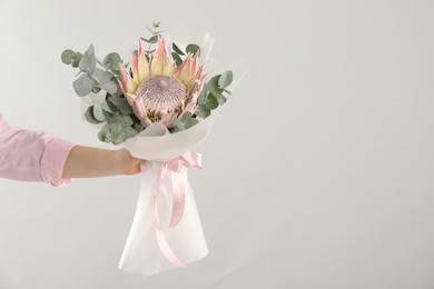 Photo of Woman with beautiful bouquet on light background, closeup. Space for text