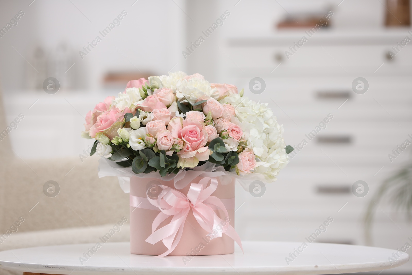 Photo of Beautiful bouquet in box on table at home