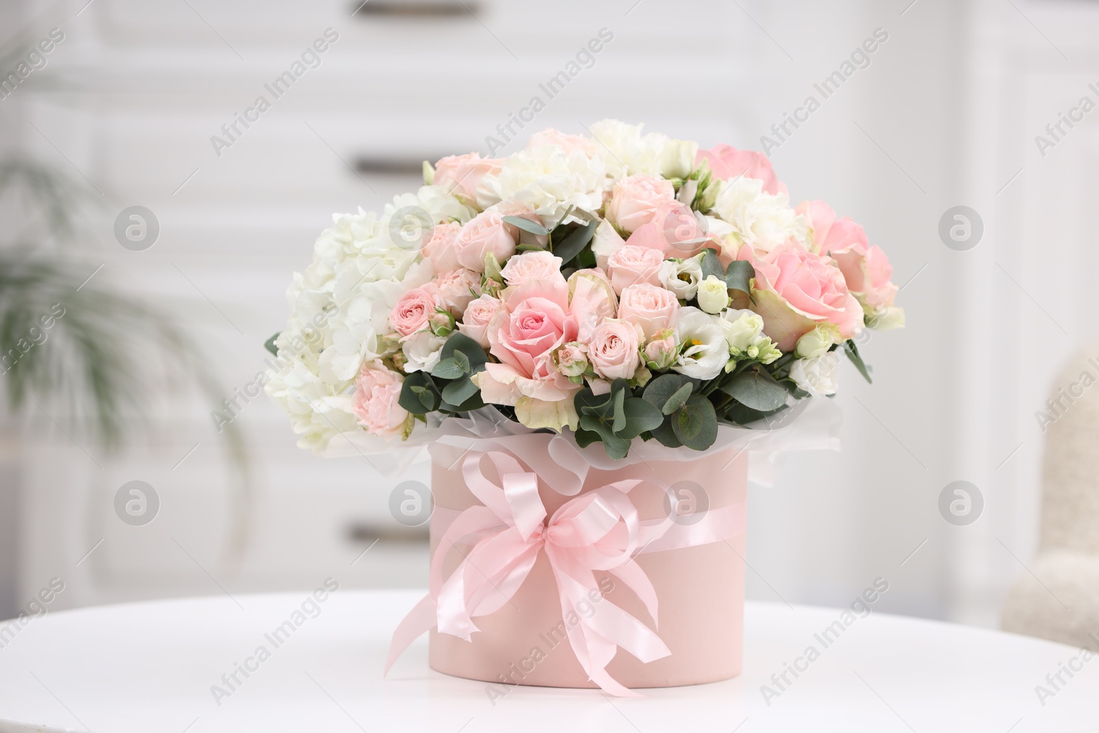 Photo of Beautiful bouquet in box on table at home