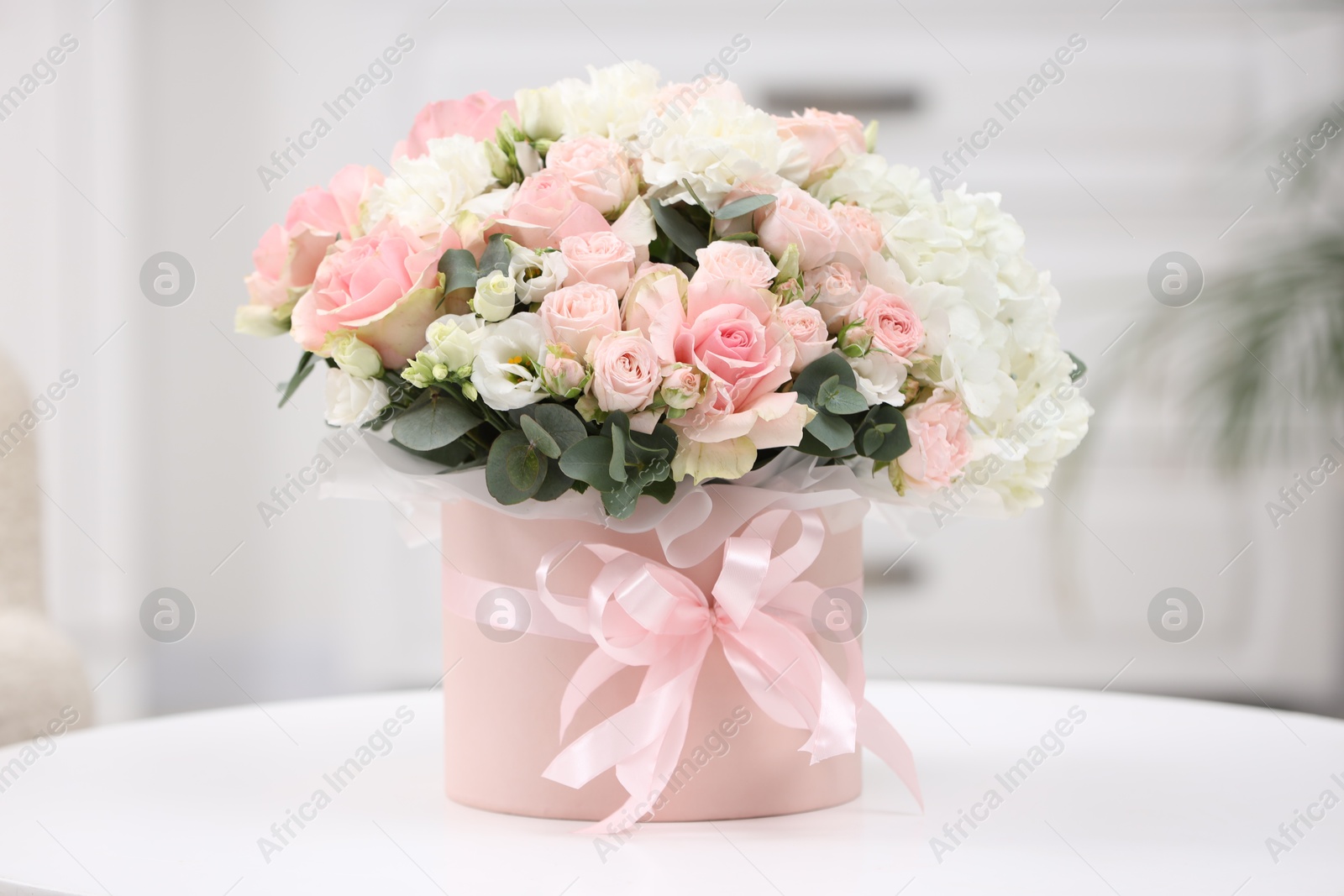 Photo of Beautiful bouquet in box on table at home