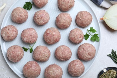 Photo of Many fresh raw meatballs on white table, flat lay