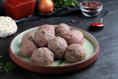 Photo of Many fresh raw meatballs on black table