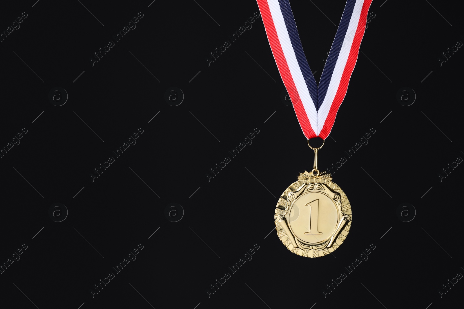 Photo of Golden medal with striped ribbon on black background, space for text