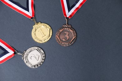 Photo of Golden, silver and bronze medals on grey background, above view