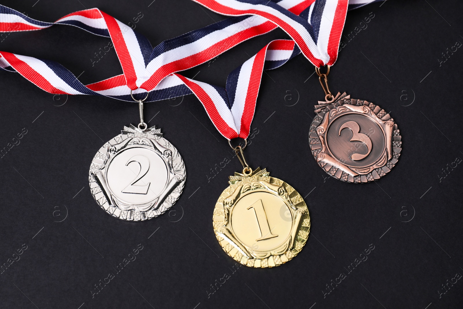 Photo of Golden, silver and bronze medals on black background, above view