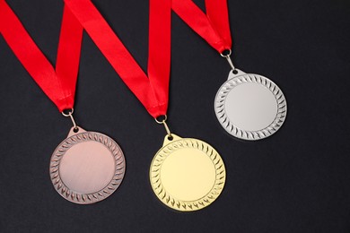 Photo of Golden, silver and bronze medals on black background, above view