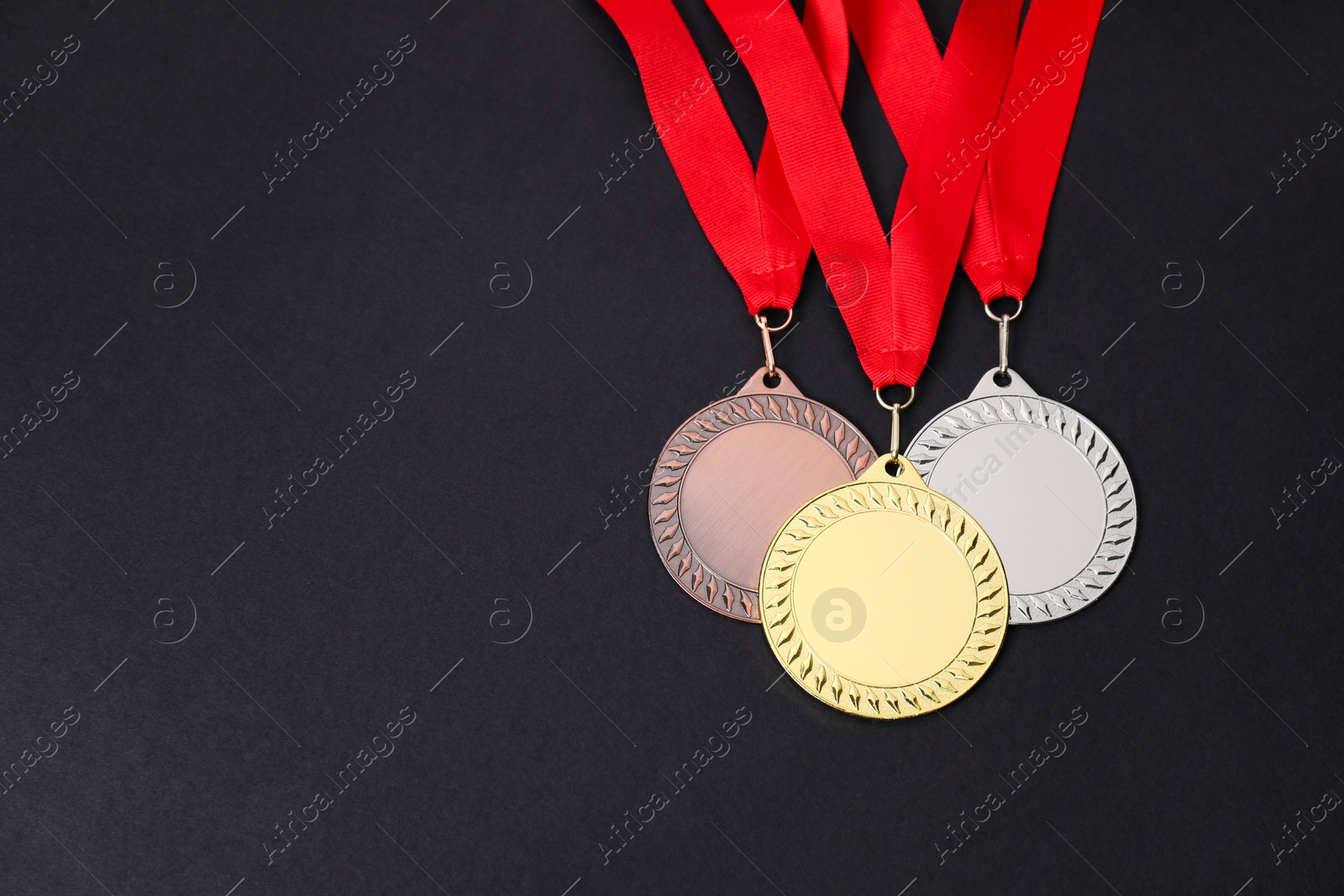 Photo of Golden, silver and bronze medals on black background, above view. Space for text