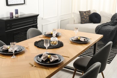 Photo of Stylish table setting with black dishware in dining room