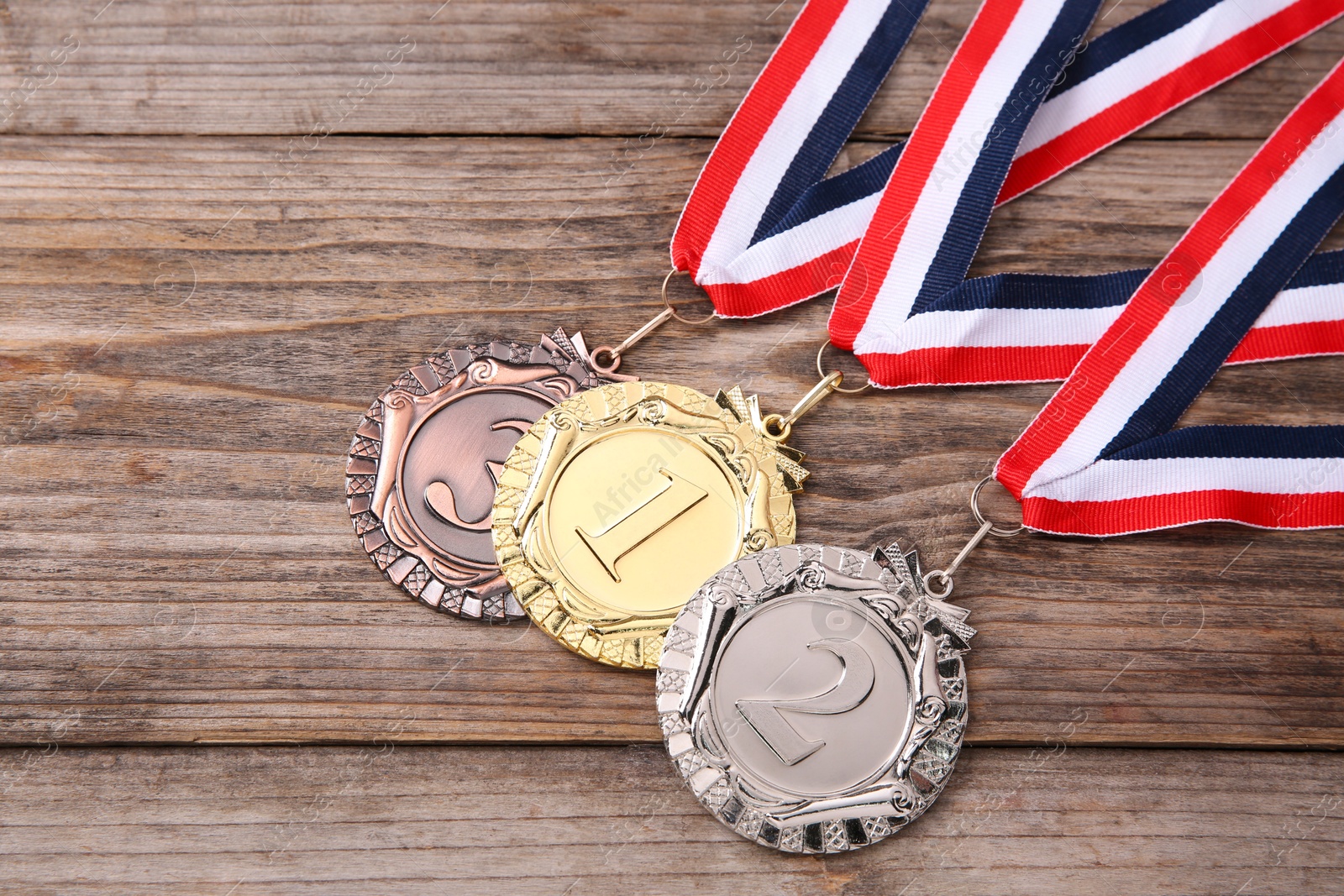 Photo of Golden, silver and bronze medals on wooden background, top view