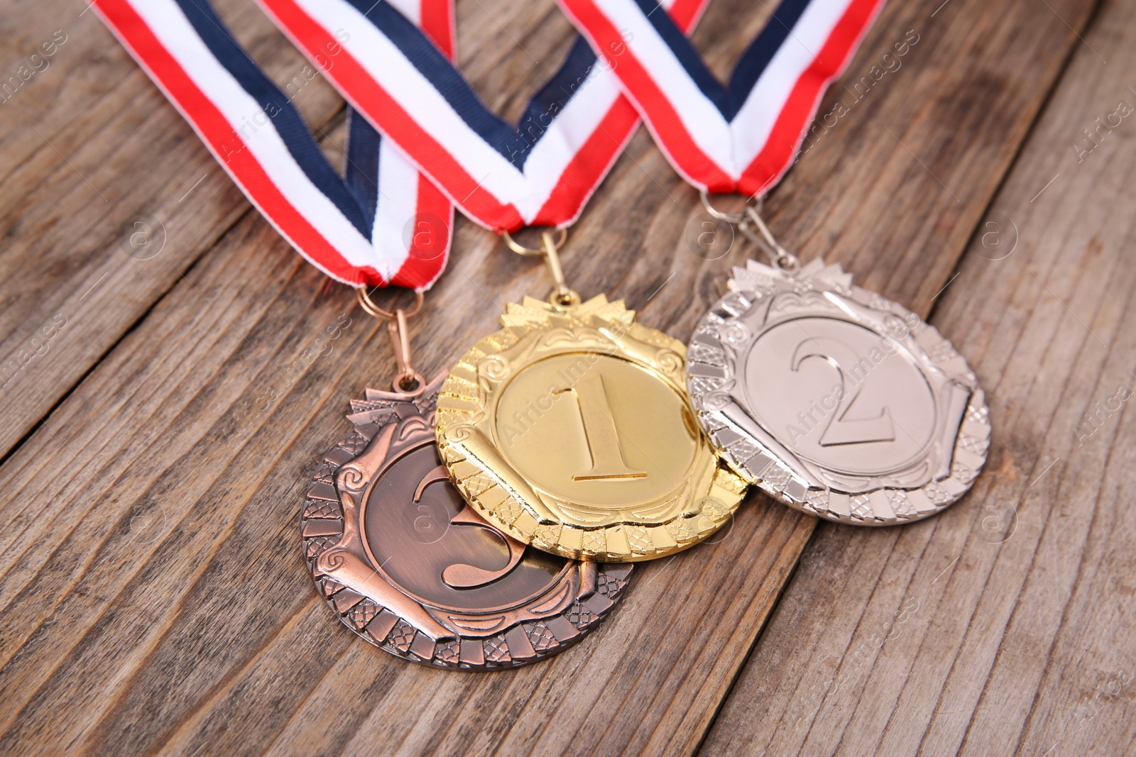 Photo of Golden, silver and bronze medals on wooden background, closeup