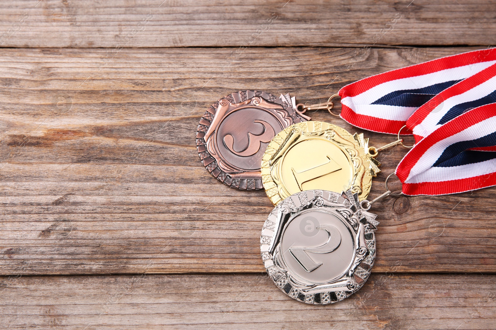 Photo of Golden, silver and bronze medals on wooden background, space for text