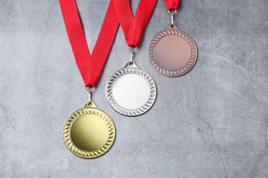 Photo of Golden, silver and bronze medals on grey background, above view