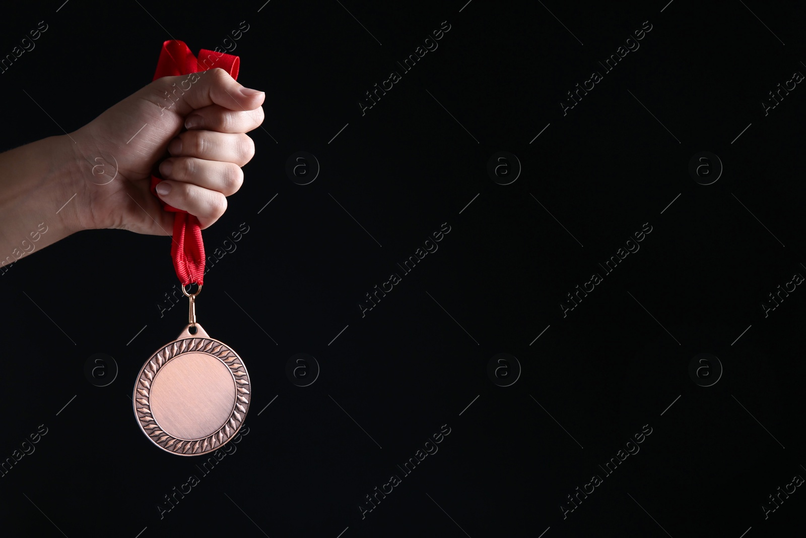 Photo of Woman with bronze medal on black background, closeup. Space for text