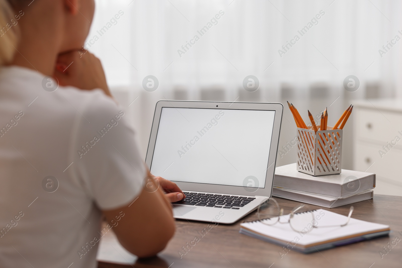 Photo of Woman working with laptop at table in office, closeup. Mockup for design