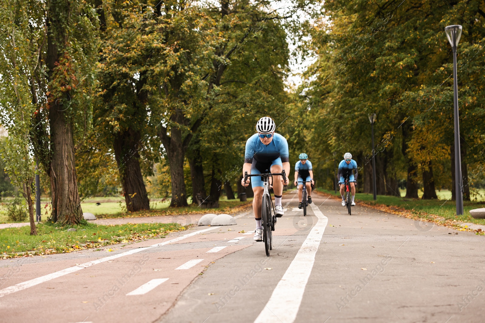 Photo of Group of athletic people riding bicycles outdoors