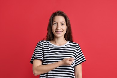 Woman making promise on red background. Oath gesture