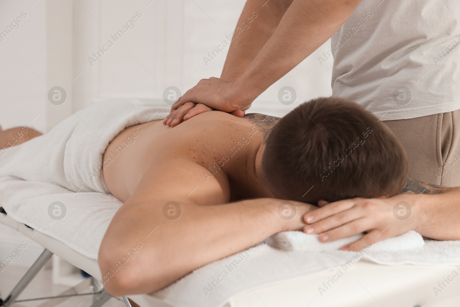 Photo of Massage therapist working with patient in clinic, closeup