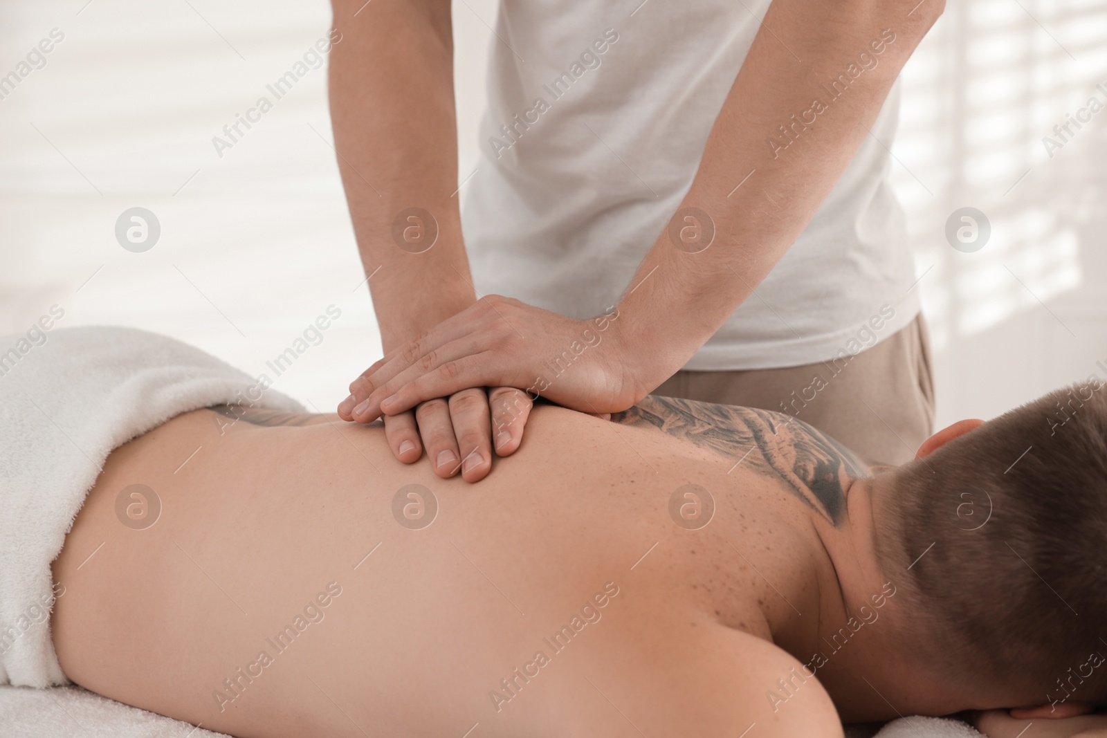 Photo of Massage therapist working with patient in clinic, closeup