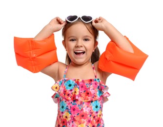 Photo of Cute little girl in swimsuit with swim armbands on white background