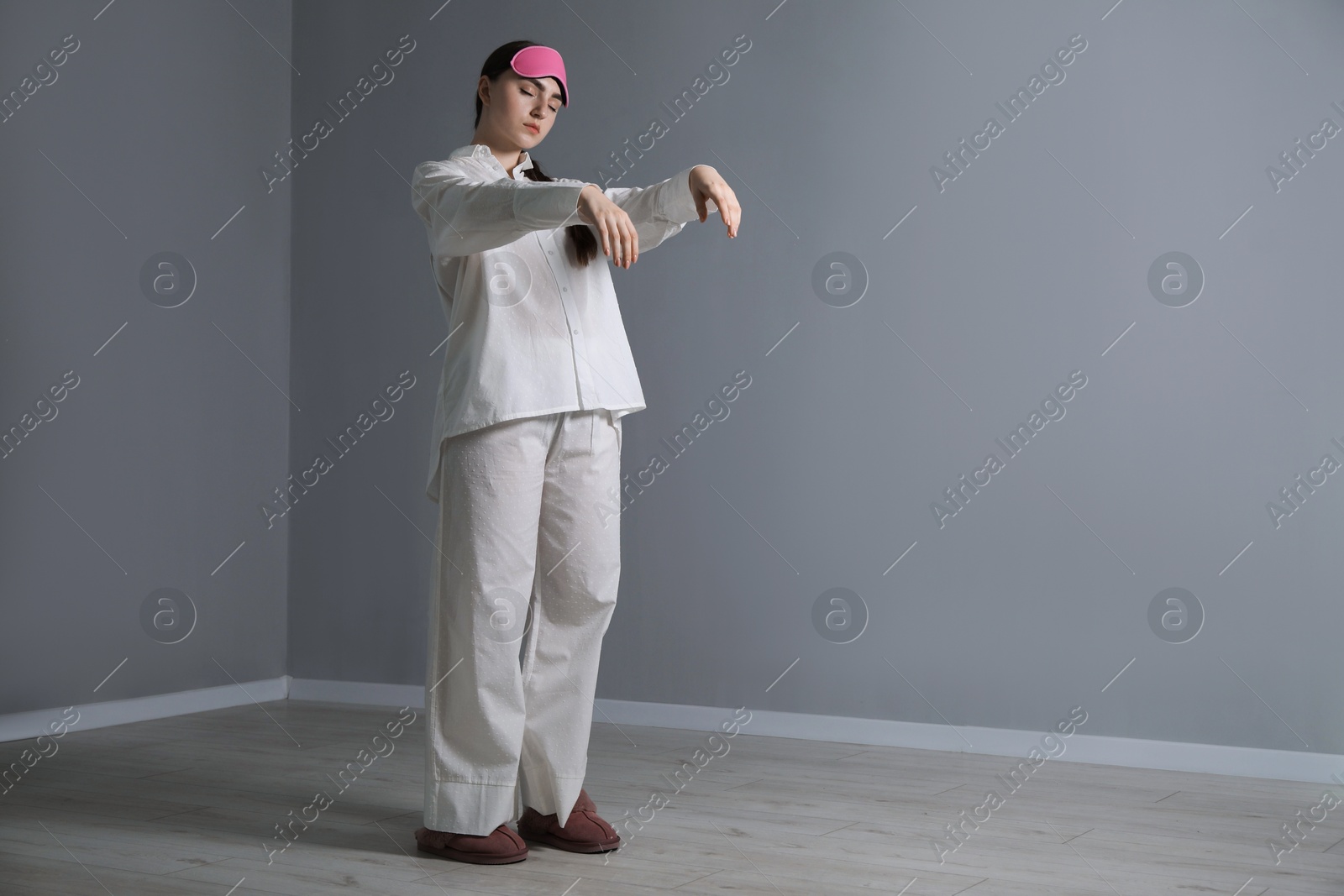 Photo of Young woman suffering from sleepwalking at home, space for text