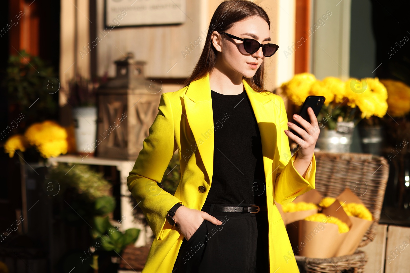 Photo of Businesswoman in stylish suit with smartphone outdoors on sunny day