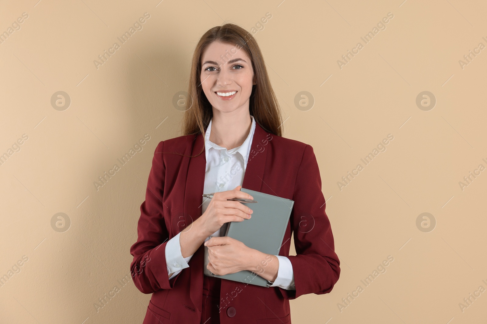 Photo of Portrait of smiling banker with book on beige background