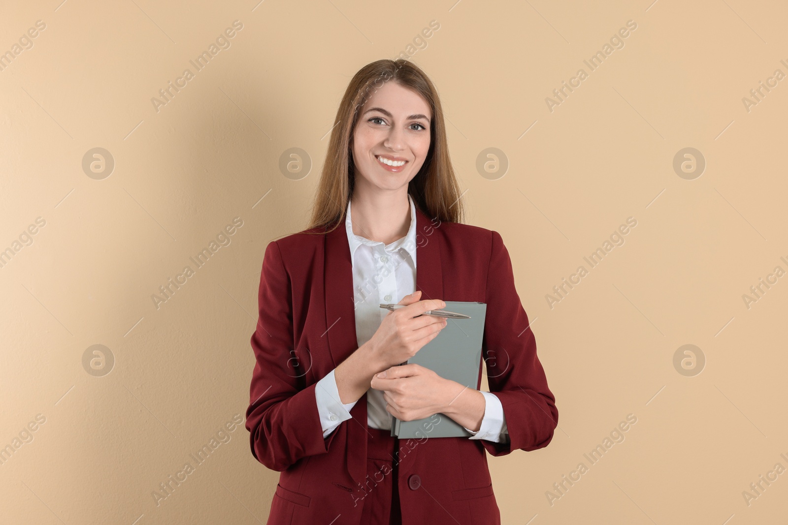 Photo of Portrait of smiling banker with book on beige background