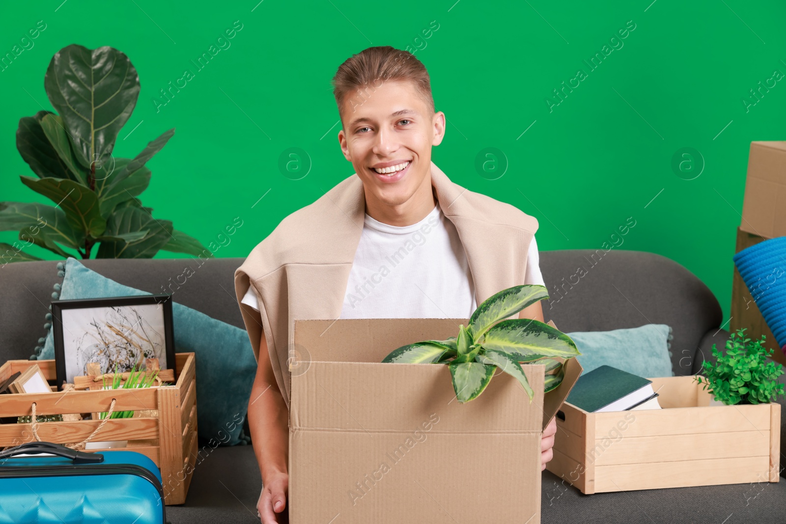 Photo of Happy man with different stuff in new apartment. Housewarming party