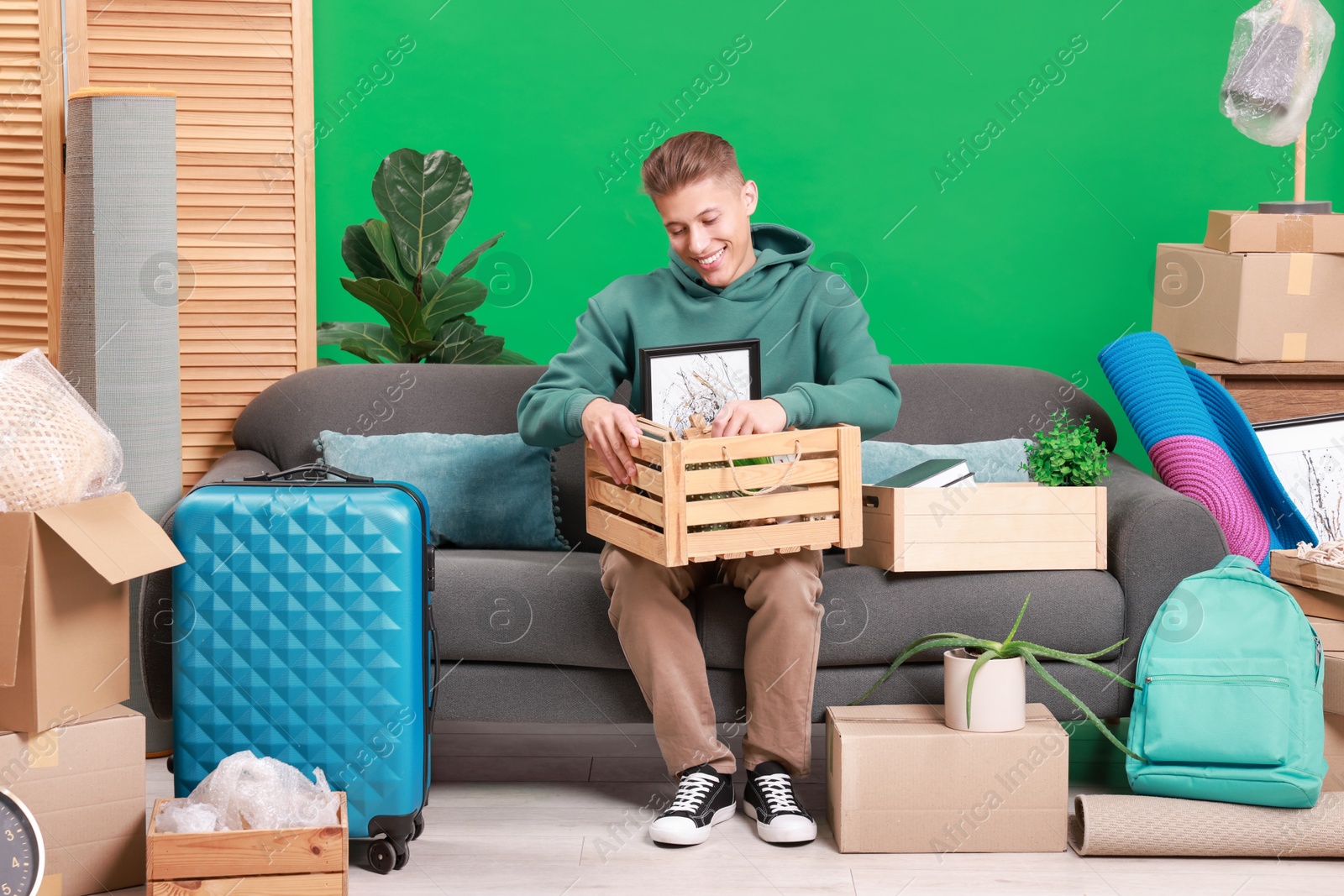 Photo of Happy man with different stuff in new apartment. Housewarming party