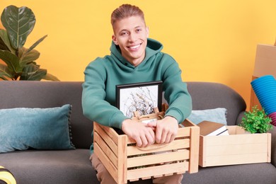 Photo of Happy man with different stuff in new apartment. Housewarming party