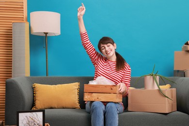 Happy woman with moving boxes in new apartment. Housewarming party