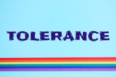 Tolerance and acceptance. Bright ribbon in LGBT colors on light blue background