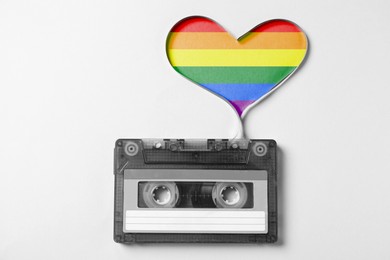 Image of Music cassette and heart made with tape on white background, top view. Colors of LGBT flag in heart. Tolerance and acceptance