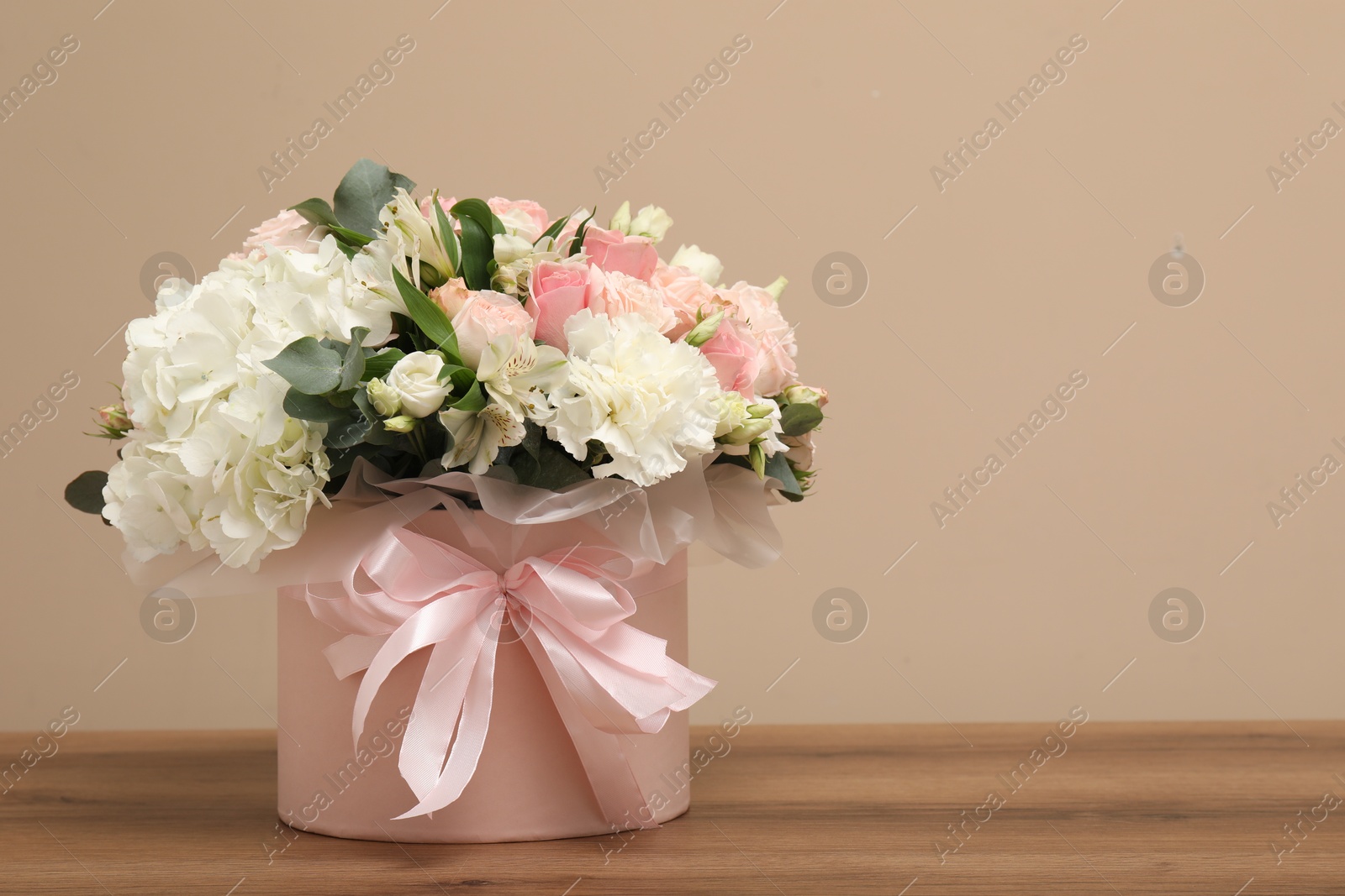 Photo of Bouquet of beautiful flowers on wooden table, space for text