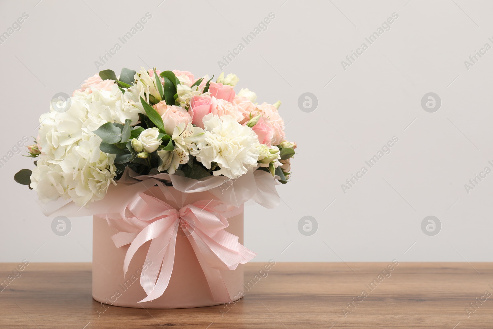 Photo of Bouquet of beautiful flowers on wooden table, space for text