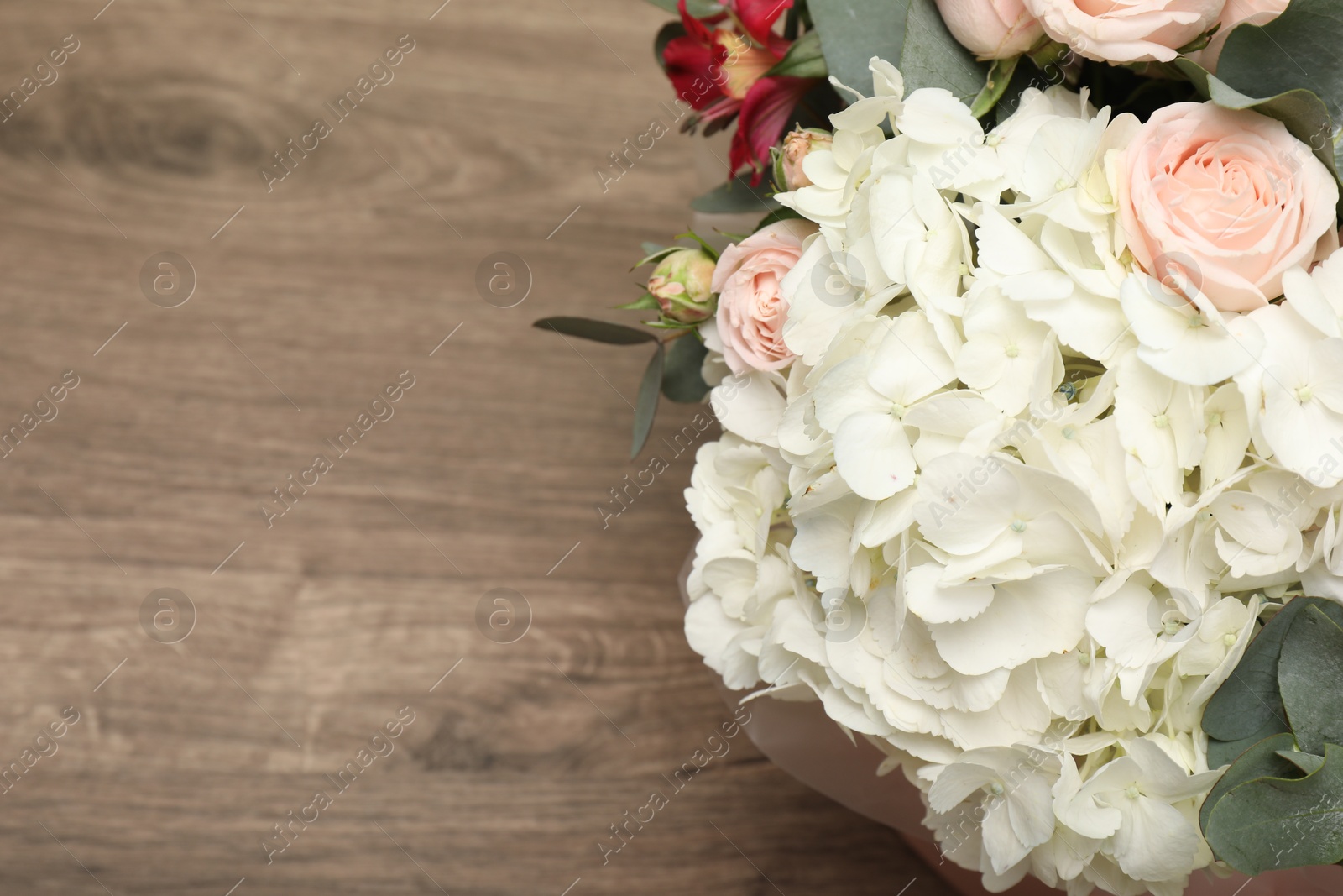 Photo of Bouquet of beautiful flowers on wooden table, top view. Space for text