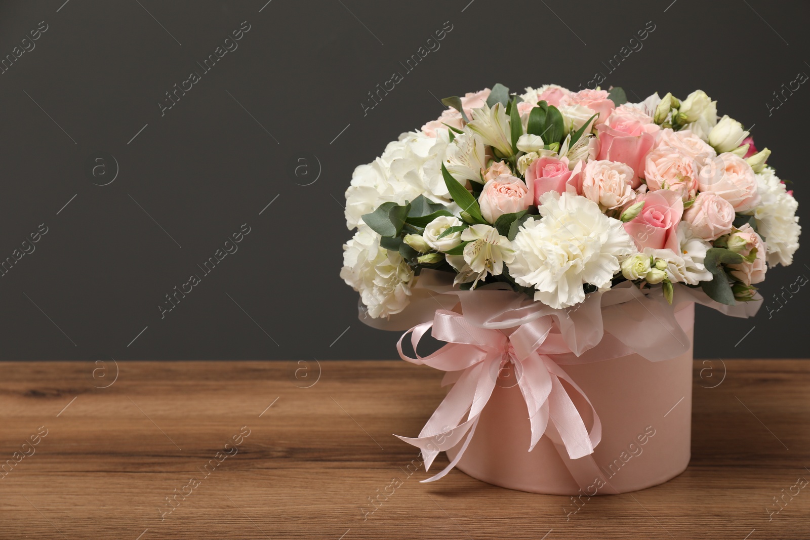 Photo of Bouquet of beautiful flowers on wooden table, space for text