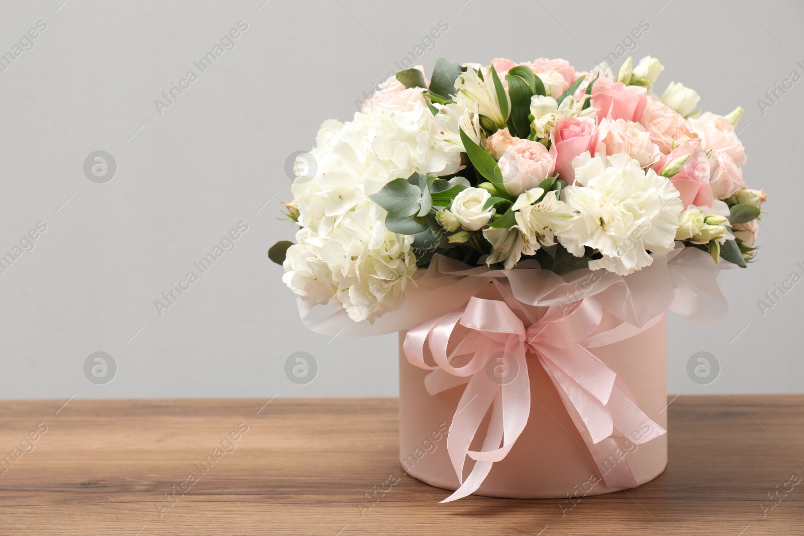 Photo of Bouquet of beautiful flowers on wooden table, space for text