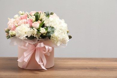 Photo of Bouquet of beautiful flowers on wooden table, space for text