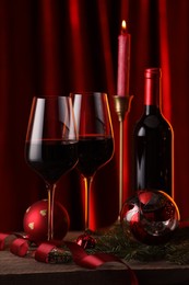 Photo of Red wine and Christmas decor on wooden table