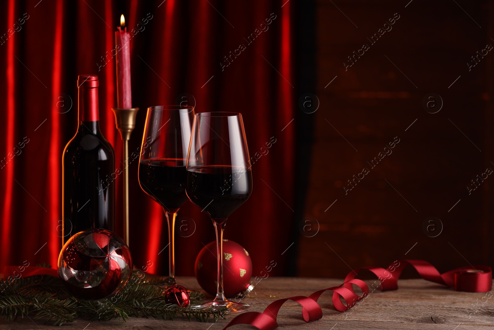 Photo of Red wine and Christmas decor on wooden table. Space for text