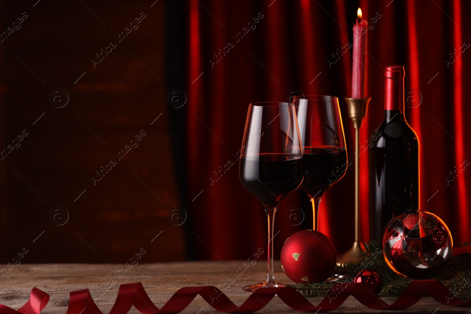 Photo of Red wine and Christmas decor on wooden table. Space for text