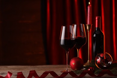 Photo of Red wine and Christmas decor on wooden table. Space for text