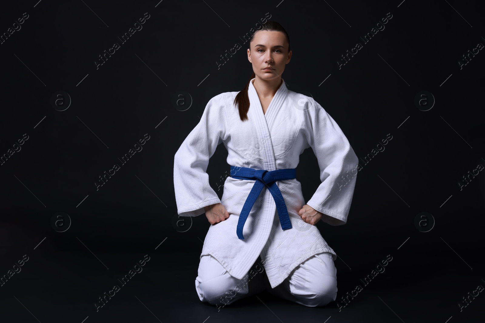 Photo of Karate fighter in kimono on black background