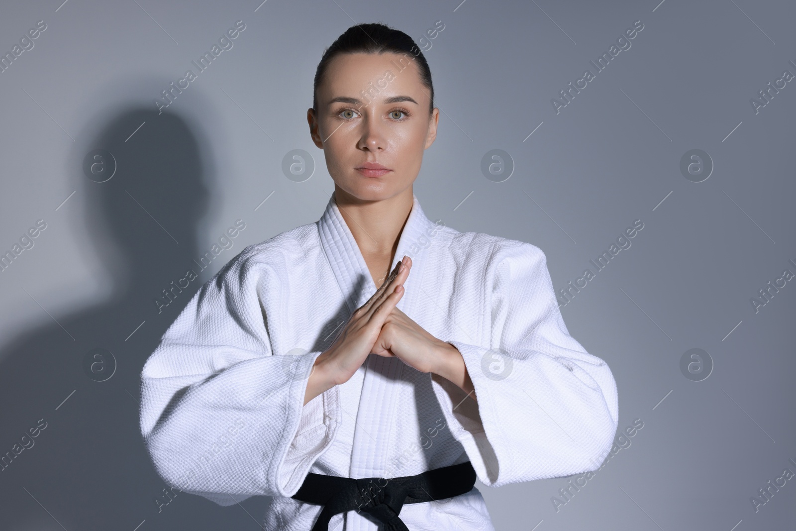 Photo of Karate fighter in kimono on grey background