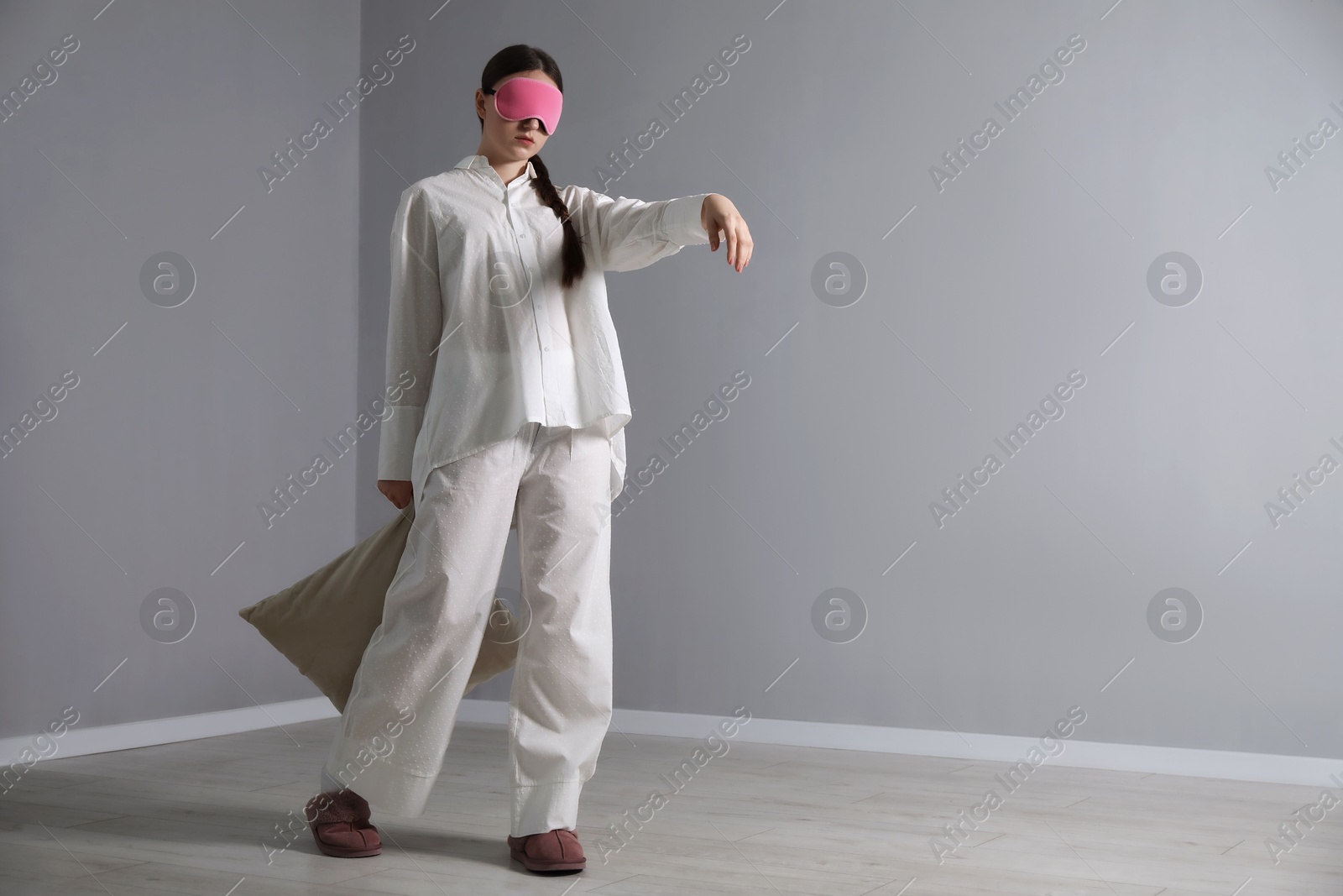 Photo of Young woman suffering from sleepwalking at home, space for text