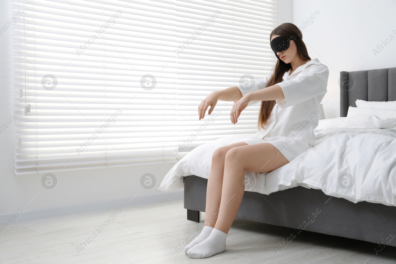 Photo of Young woman suffering from sleepwalking at home, space for text