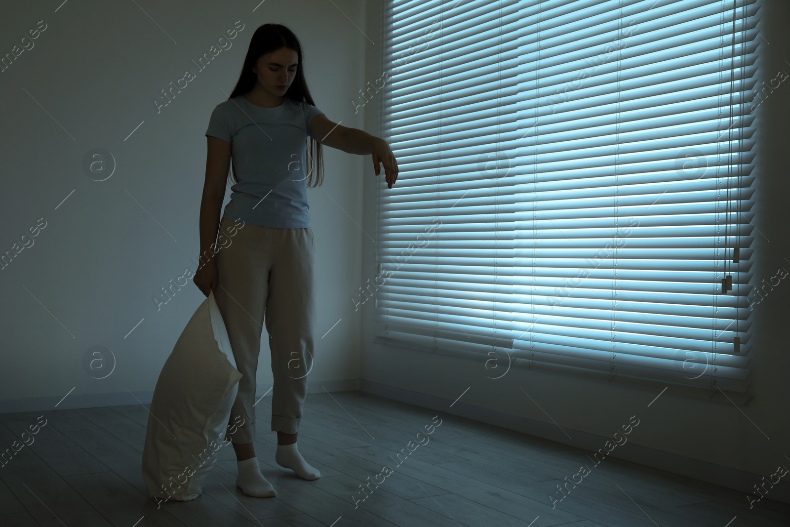 Photo of Young woman suffering from sleepwalking at home, space for text