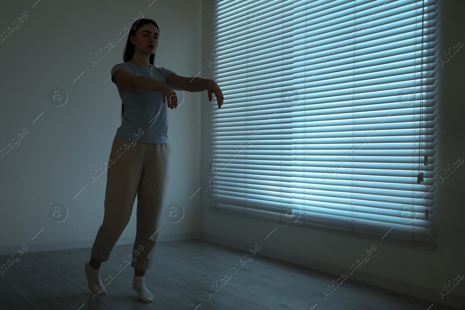 Photo of Young woman suffering from sleepwalking at home, space for text