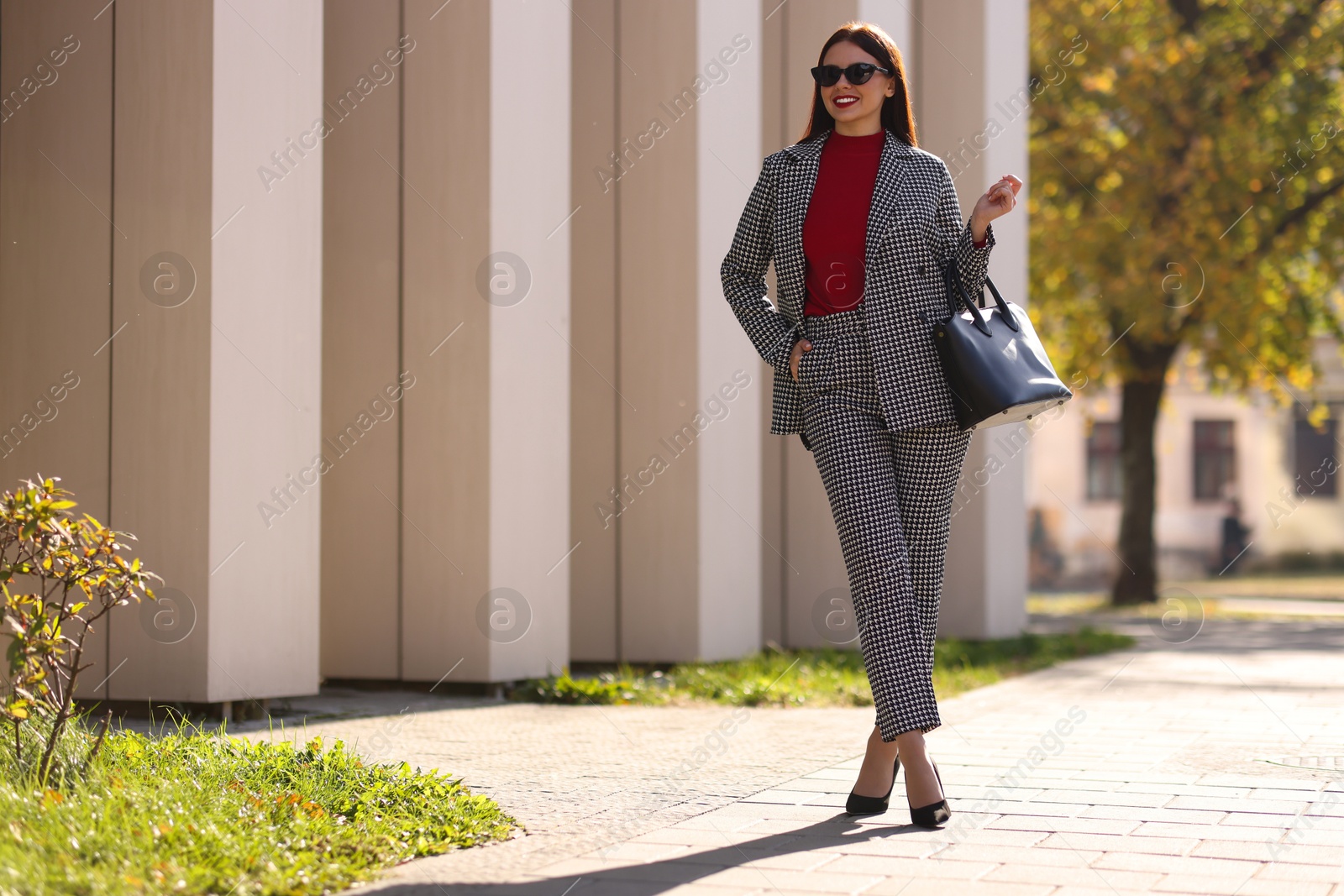 Photo of Smiling businesswoman in stylish suit outdoors on sunny day. Space for text